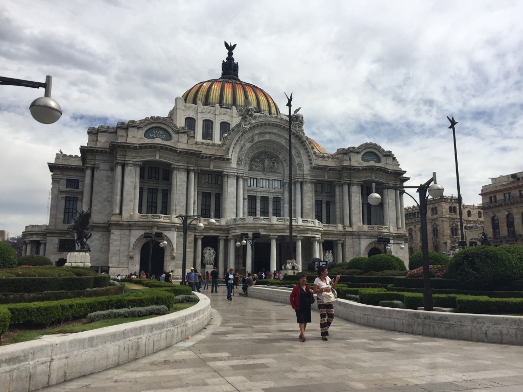 Tourists walk around palacio bellas artes in downtown mexico city.