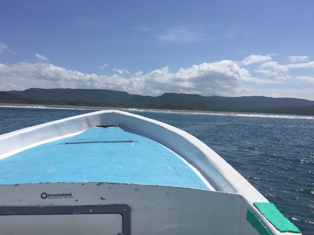 The bow of a boat headed towards a pristine beach in Costa Rica.